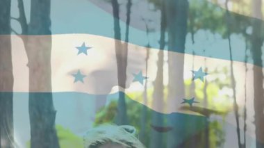 Pazarlama için Grove 'da gülümseyen güneş gözlüğü takan genç büyükelçi bayrağı sallıyordu. Vatanseverlik, gençlik, açık hava, güneş ışığı, gündelik, doğa, tazelik