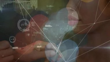 Makyaj sanatçısı fırçayı dudak parlatıcısına batırıyor, model dudaklara parlatıcı sürerek güzellik örtüsü uyguluyor. Güzellik, sofistike, yüksek teknoloji, zarafet, cazibe, dijital, sanatçılık