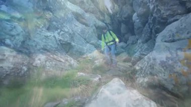 Yürüyüşçü yarıktan çıkıyor ve yamaçtan güvenli bir şekilde iniyor. Teknolojik grafikler bağlantıyı vurguluyor. Macera, keşif, açık hava, engebeli, teknoloji, bağlantı, vahşi doğa.