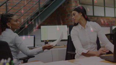 Siyahi kadın ofisteki meslektaşına belge uzatıyor, ikili örtülü olarak veri incelemesi yapıyor. İşbirliği, takım çalışması, dijital, profesyonel, kentsel, modern, iletişim