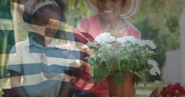 Anne malayı veriyor, kızı kabul ediyor bahçe eğitimi için papatya tohumu ekiyor. Aile, bahçıvanlık, açık hava, doğa, yetiştirme, büyüme, uyum