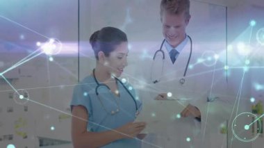 Doktor tableti tıklatıyor ve hasta bakımı için veri görselleştirmesi üzerinden hemşireye rehberlik ediyor. Sağlık, işbirliği, dijital, teknoloji, profesyonellik, yenilik, iletişim