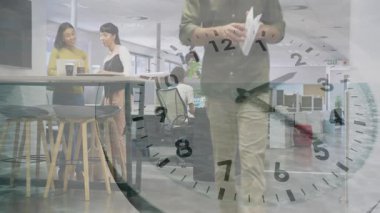 Kadınlar kahve fincanlarını ofise koyarlar, saat çizelgesine göre adam elinde kağıtlarla yürür. İşbirliği, birlikte çalışma, modernleşme, işyeri, iletişim, takım çalışması, profesyonel