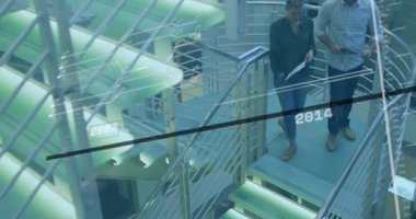 İş ekibi spiral merdivenlere çıkıyor zaman çizelgesini aktifleştiriyor ve dizüstü bilgisayarın verilerini inceliyor. Profesyonel, takım çalışması, modern, yenilik, şirket, işbirliği, şirket tarzı