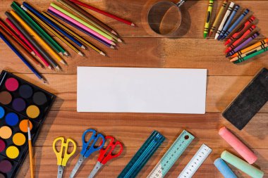 Tahta masadaki okul malzemeleriyle dolu boş bir kağıdın hemen üstünde.