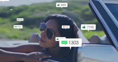 Havacı güneş gözlüklü Hintli kadın tepelerden arabayla geçerken medya simgelerine bakıyor. Özgürlük, macera, açık hava, yaz, yaşam tarzı, boş zaman, çağdaş