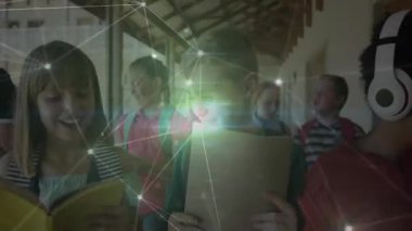 Okul koridorunda yürüyen çocuklar pano ve kitap notlarını karşılaştırıyor, ağ örtüsü görünüyor. Eğitim, öğrenme, işbirliği, çeşitlilik, okul, sınıf, teknoloji