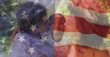 Aile üçlüsü çocuğu tutuyor ve bahçede öpüşüyor, reklam bayrağı portreyi gözler önüne seriyor. Aile, şefkat, birlik, birliktelik, açık hava, kutlama, sıcaklık.