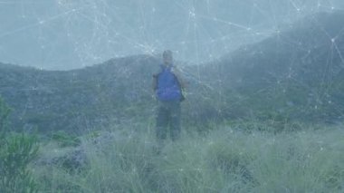 Yürüyüşçü, kayalık yamaçta yürüyüş yaparken mavi sırt çantalarını sıkarak orta tepeye ulaşıyor. Macera, keşif, yürüyüş, açık hava, vahşi doğa, engebeli doğa.