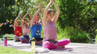 Güvertede yoga minderleri düzenleyen arkadaşlar, soldan süzülen emoji simgeleri gibi sağlıkları için meditasyon yapan arkadaşlar. Doğa, dinginlik, farkındalık, ahenk, rahatlama, açık hava, sağlık.