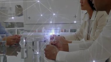 İş adamları cam masaya kalem yerleştiriyor. Ağ atımlarıyla beyin fırtınası başlatıyorlar. İşbirliği, şirket, modern, teknoloji, ağ, takım çalışması, yenilik