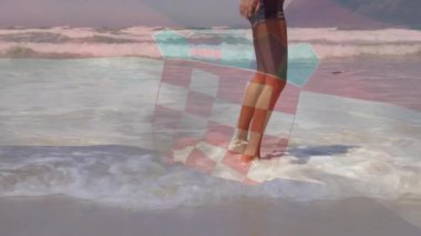Kadının sığ dalgalara girdiği, köpüklü ayak bilekleriyle kıyı yürüyüşüne çıktığı bir gezi sahnesi. Sahil, deniz kenarı, boş zaman, gezgin, kaygısız, doğal, açık hava