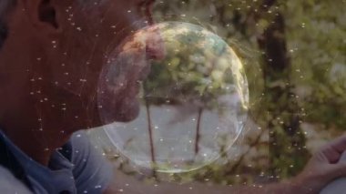 Ağ düğümleri görünen bir dünyada, insan pusulayı seçiyor, haritada navigasyon için iğneyi hizalıyor. Macera, keşif, açık hava, navigasyon, teknoloji, yaban hayat, takım çalışması