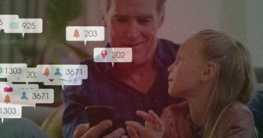 Son sınıf öğrencisi kızına akıllı telefon gösteriyor ve kaynaşma sırasında yüzen sosyal medya simgeleri yaratıyor. Aile, bağ, teknoloji, nesiller arası, bağlantı, yaşam tarzı, iletişim