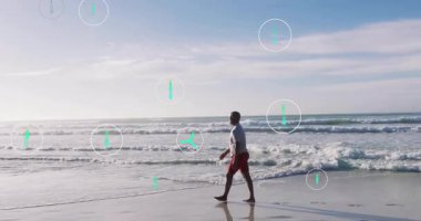 Sahil şeridinde yürüyen bir adam yüzen rüzgar türbini geri dönüşüm ikonlarını başlatarak çevreyi gösteriyor. Sürdürülebilirlik, çevre dostu, teknoloji, koruma, sükunet, yenilik, gelecek