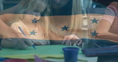 Genç kız, eğitim için yeşil kağıda şekiller çizen annesinin rehberliğinde mavi kalem seçiyor. Aile, eğitim, yaratıcılık, bağlanma, öğrenme, çocukluk, ev