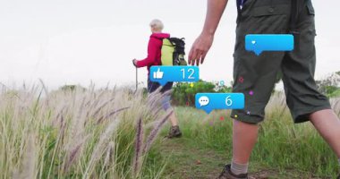 Erkek çimenleri fırçalarken kadınlar yürüyüş yapıyor sosyal medya simgelerini etkinleştiriyor ve nişanı gösteriyor. Macera, keşif, doğa, yürüyüş, açık hava, sağlık, fitness