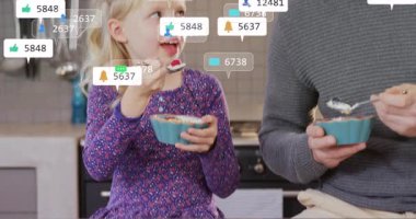 Baba ve kızı yoğurt kepçeleme ve mutfakta tatma sırasında canlandırılmış tepki simgelerini etkinleştirme. Aile, beslenme, dijital etkileşim, rahat, bağlanma, ev yemeği, modern