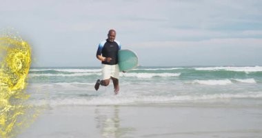 Elinde sörf tahtası olan sörfçü, teknoloji pazarlaması için altın kurdele takıyor. Enerji, macera, canlılık, dinamik, maneviyat, kıyı, hareket