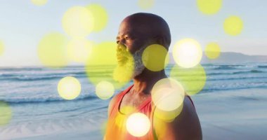 Erkek koç gün doğumunda sahilde dua ederek farkındalık egzersizi yapıyor. Dalgalarla, altın bokeh sürükleniyor. Meditasyon, dinginlik, maneviyat, sağlık, farkındalık, sükunet, doğa.