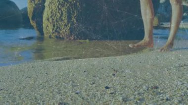 Kıyı şeridinde çıplak ayakla yürüyen, güneş ışığında sörf yapan ve seyahat kliplerinde dalgalanmalar yaratan biri. Kıyı, kıyı şeridi, yalınayak, deniz manzarası, dalgalar, sükunet, doğa