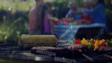 Kömür akıllı ızgara mısır, köfte ve aile yemeği paylaşırken veri gönderiyor. Açık hava, arka bahçe, aile, teknoloji, ızgara, piknik, toplanma