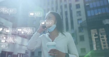 Ofis dışından bir kadın arıyor, elinde kahve, telefonunda nişan takibi yapan sosyal medya ikonları var. Kentsel, profesyonel, modern, canlı, bağlantı, dijital, yaşam tarzı