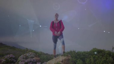 Kırmızı ceketli ve sırt çantalı bir kadın kollarını kaldırıyor. Teknoloji için animasyon ağı kuruyor. Yürüyüş, macera, keşif, teknoloji, bağlantı, moleküler, doğa