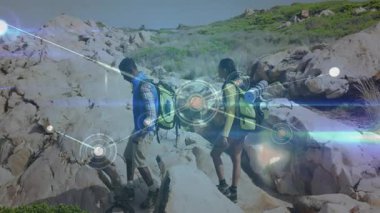 Yürüyüşçüler kayalık kıyı şeridinde kütüğe basıyor, dijital örtülerin büyüdüğünü görüyor, arazinin haritasını çıkarıyorlar. Macera, keşif, bağlantı, doğa, açık hava, teknoloji, dayanıklılık