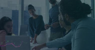 Dijital grafikler büyüyüp veri analizine rehberlik ederken dizüstü bilgisayarın etrafında beş kişilik bir ekip verileri tarıyor. İşbirliği, takım çalışması, analitik, iş, yenilik, dijital, sunum