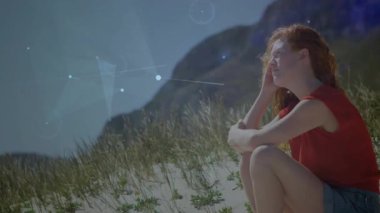 Çömelmiş, çömelmiş, ufukta beliren noktalara bakan bir kadın. Teknoloji şemasını aydınlatan bir ağ oluşturuyor. Macera, keşif, yenilik, dijital, fütüristik, huzur, manzara