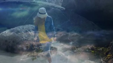 Gelgit havuzuna giren bir kadın ağ oluşturarak teknolojik veri görselleştirmesini ortaya çıkarıyor. Deniz kenarı, keşif, macera, doğa, teknoloji, dijital, engebeli