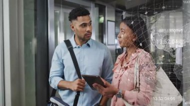 Erkek, iş ölçümlerini belirten tablet verileri ile koridorda kadına katılıyor. İşbirliği, teknoloji, veri, yenilik, iş, takım çalışması, analitik