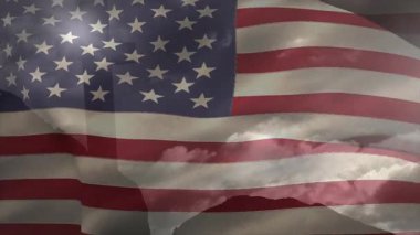 Hafif bir esinti Amerikan bayrağını kaldırıyor ve dalgalanan hareketler sergiliyor. Vatanseverlik, ulusal sembol, açık hava sahnesi, kumaş hareketi, manzara, çevre, hareket