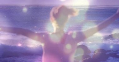 Güneş ışığı, plajda Bokeh 'le birlikte kendini iyi hissetmek için kollarını açan mercek parlamaları yaratıyor. Doğa, rahatlama, dinginlik, hareket, uyum, açık hava, özgürlük.