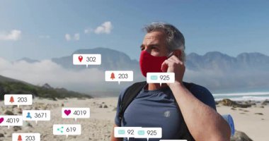 Kumsaldaki akıllı telefonlara rahatlamak için cevap veren adam, yüzen sosyal medya ölçümleri yaratıyor. Macera, açık hava, refah, teknoloji, iletişim, doğa, huzur