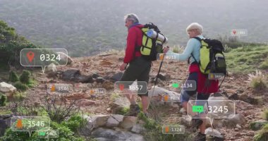 Yürüyüş yapan çift yüzen konum iğnelerini gösteren fitness teknisyenlerini kullanarak kayalık patikaya tırmanıyor. Macera, keşif, teknoloji, açık hava, dayanıklılık, takım çalışması, manzara