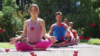 Tahta güvertede oturan yoga uzmanları iyileşmek için dönen kalpler alıyorlar. Sağlık, meditasyon, rahatlama, uyum, doğa, farkındalık, sükunet