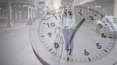 Saat ellerinin teknolojiyi süpürüp geçerken kadın bisiklet izleme zamanı geçidini zorluyor. Kentsel, gündelik, zamansız, hareket, şehir manzarası, yaşam tarzı, modern
