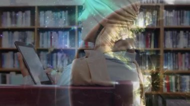 Bayan öğrenci tableti tıkırdatıyor ve dünya ışıklarını etkinleştiriyor ve kütüphanede eğitim verilerini araştırıyor. Gelecekçi, yenilikçi, dijital, teknoloji, eğitim, araştırma, analitik