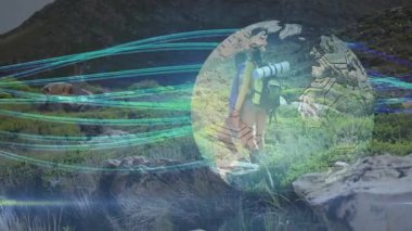 Dönen teknoloji dünyasına akan ekran dışı ışık akışları kayalık patikadan geçen yürüyüşçüleri gösteriyor. Macera, keşif, teknoloji, yenilik, esneklik, açık hava, engebeli