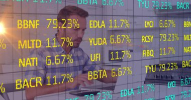 Modern ofiste dizüstü bilgisayarda mavi tişörtlü, orta yaşlı bir adam yazıyor. Teknoloji, yenilik, üretkenlik, iş akışı, çağdaş, dijital, kurumsal