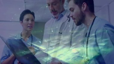 Tableti işaret eden genç klinisyen ekip sağlık incelemesi yaparken 3D veri göndermeye başladı. Tıbbi, takım çalışması, fütüristik, yenilik, sağlık, işbirliği, analiz