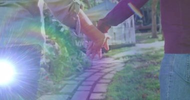 Yaşam tarzı ilanı, olgun bir çiftin taştan yola tutunduğunu güneş ışığı altında yürüdüğünü gösteriyor. Bağlantı, arkadaşlık, uyum, dinginlik, açık hava, eğlence, yeşillik