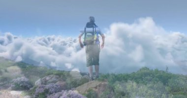 Erkek yürüyüşçü zirvede duraklıyor kaya üzerinde adım atıyor kollarını kaldırıyor seyahat için bulut ufkunu kucaklıyor. Macera, dağ, keşif, vahşi doğa, açık hava, yükseklik, meydan okuma