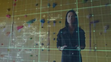 Tırmanma duvarının önünde duran kadın, şematik haritalama teknolojisiyle ızgarayı başlatıyor. Gelecek, teknoloji, arayüz, yenilik, veri, sanal, dijital