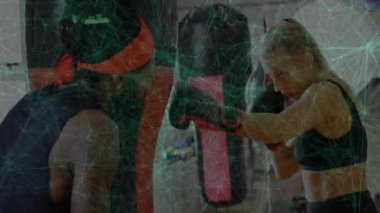 Kadın stajyer boks salonuna giriyor, pedlere kombinasyonlar atıyor ve hareketli metre rehberli yumruklar atıyor. Eğitim, spor, güç, disiplin, esneklik, enerji, motivasyon