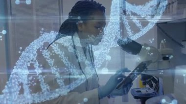 Genomik laboratuvarına giren araştırmacı DNA sarmalı ile mikroskop altında tablet teftişi yapıyor. Biyoteknoloji, yenilik, kesinlik, eğitim, bilim, analiz, dijital