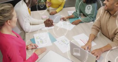 İş arkadaşları çizelgeleri gözden geçiriyorlar. Canlandırılmış simgelerin toplanmadan önce birbirlerine notlar vermelerine neden oluyorlar. Takım çalışması, işbirliği, analiz, strateji, yenilik, profesyonellik, ofis