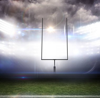 Futbol kale direği düz dizaynla çimlerin üzerinde duruyordu, projektörler bulutlu gökyüzünün altında parlıyordu. Spor, açık hava, gece, aydınlatma, atmosfer, stadyum, yarışma